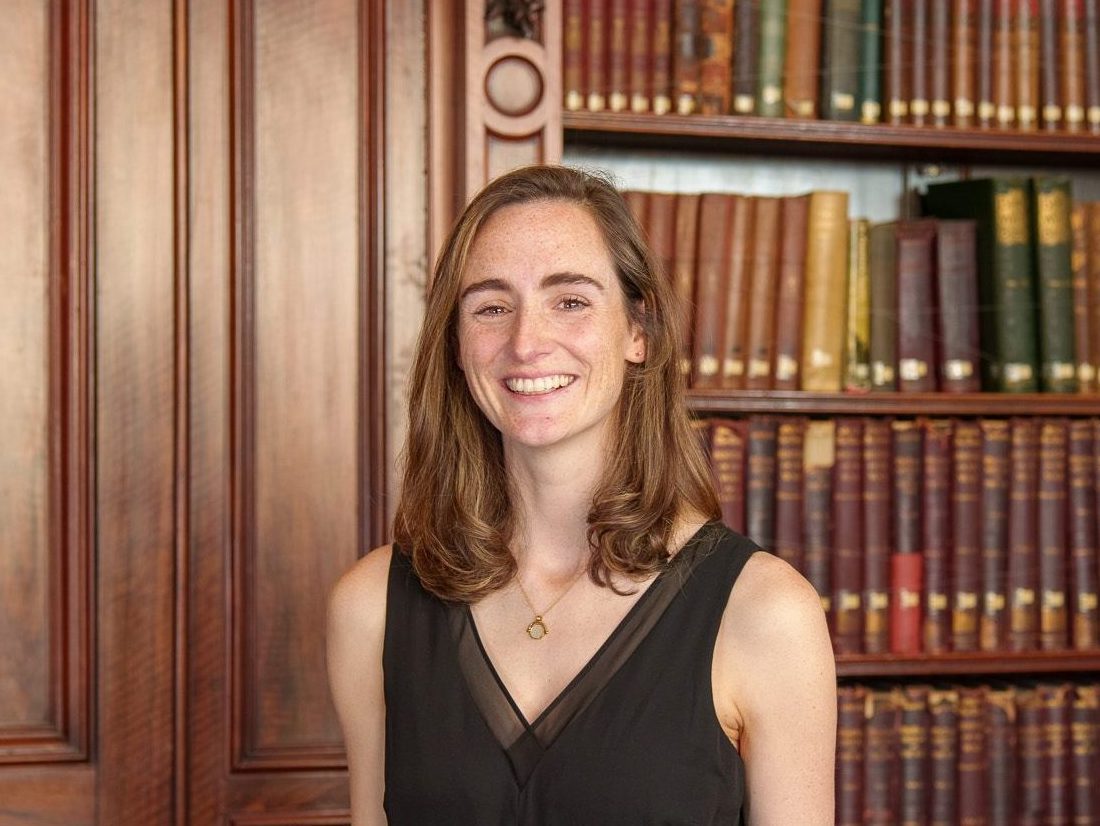 Molly Bertram standing in front of the library books in the Members' Library