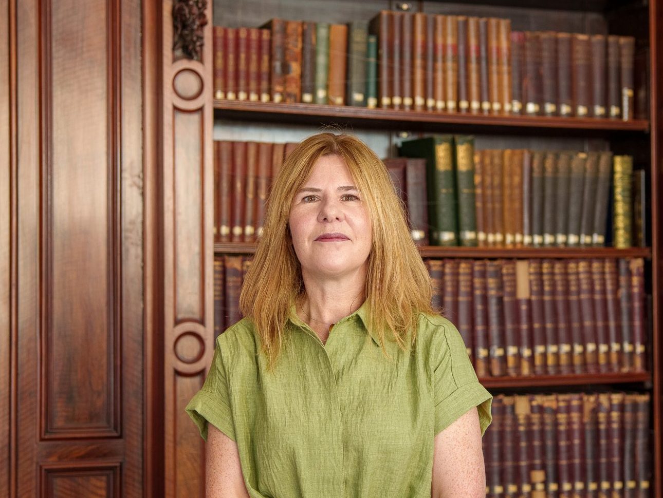 Heather Blair standing in front of the library books in the Members' Library